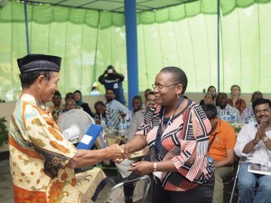 A workshop participant from Uganda meets an Indonesian district leader and family planning champion during a site visit.